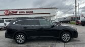 Black SUV parked in the foreground at an E-Z Loan Auto Sales dealership with other cars and a white building behind.