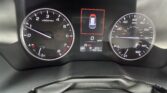 Center dashboard display showing a top-down car icon inside a red outline (parking status), flanked by a tachometer on the left and a speedometer on the right; the odometer reads 115,610 miles.