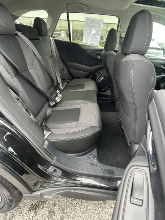 Interior of a black SUV rear cabin with gray fabric seats and three-point seat belts visible in the back row.