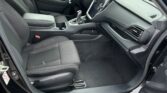 Interior of a dark SUV: front seats, center console, steering wheel, and dashboard with touchscreen in view.