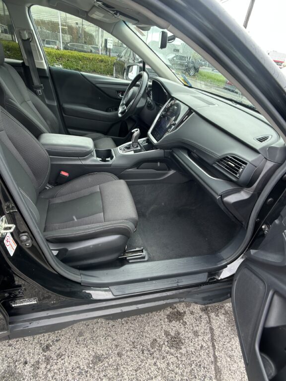Interior of a dark SUV: front seats, center console, steering wheel, and dashboard with touchscreen in view.