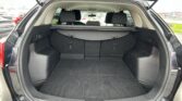 Open SUV trunk with cargo cover in place and rear seats upright, showing a clean, empty cargo area.