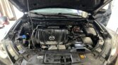 Open car hood revealing the engine bay, including the SkyActiv Technology engine cover and surrounding components