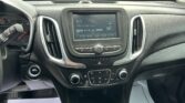 Car dashboard interior with center touchscreen showing FM radio 96.9 and climate controls nearby.