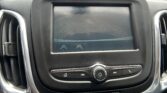 In-dash display showing the car's rearview camera feed with red parking guideline lines in a parking lot
