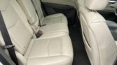 Rear passenger area of a beige leather SUV with panoramic sunroof and front seats visible.