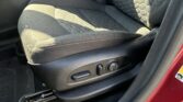 Front passenger seat and center console area of a car, showing fabric seat with textured pattern and seat controls on the side.