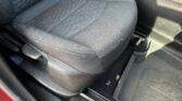 Front passenger seat in a GMC, with a red seat belt buckle between the seat and center console.