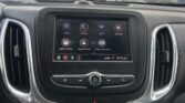 Car interior with a center touchscreen displaying app icons (Audio, Phone, Wi‑Fi) and climate controls below.