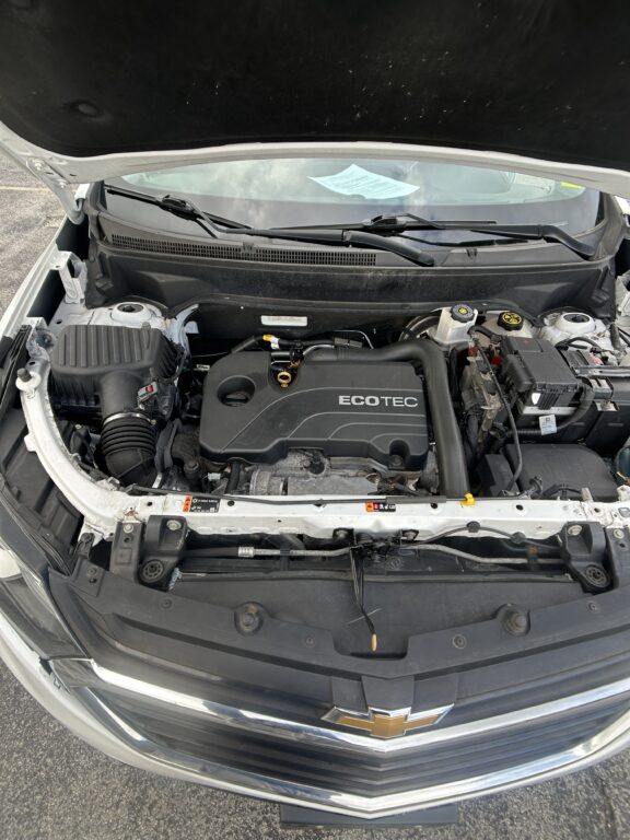 Front view with hood open showing Chevrolet engine bay and ECOTEC engine cover, wipers in the windshield area, car parked on pavement