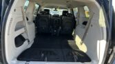 SUV interior cargo area with third-row seats folded flat and beige side panels, showing spacious trunk space