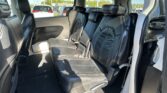 Rear interior of a black leather SUV with two captain chairs and a third middle seat, headrests visible by windows.