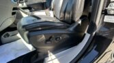 Black leather front seats and center console inside a car, with the open passenger door visible.