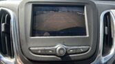 Rear-view camera display showing parking lot with orange guiding lines for backing up in a car