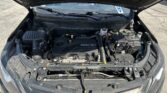 Open car hood exposing engine bay with an ECOTEC engine cover, battery, and fluid reservoirs visible in a Chevrolet vehicle.