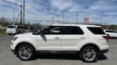 White SUV in a dealership parking lot with power lines overhead and an EZ LOAN Auto Sales sign in the background.