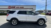White SUV parked in front of E-Z Loan Auto Sales storefront on a sunny day
