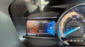 Dashboard close-up showing speedometer and warning lights; 'Driver Door Ajar' alert illuminated, odometer reads 122,755.5 miles.