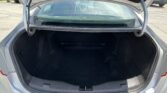 Open trunk of a silver sedan with an empty cargo area in a parking lot.