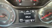 Vehicle instrument cluster showing speedometer (right), tachometer (left), and central digital display with trip data and mileage.