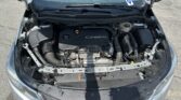 Open hood view of a Chevrolet engine bay with an Ecotec engine cover and surrounding hoses and components visible in the front of the car