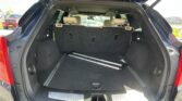 SUV rear cargo area with third-row seats folded down, showing open hatch and rails on the floor for cargo.