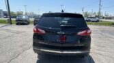 Rear view of a black Chevrolet Equinox in a parking lot with other cars and a dealership in the background](https://)