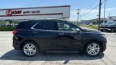 Black Chevrolet Equinox SUV parked in front of an E-Z Loan Auto Sales building on a sunny day with a Toyota dealership visible in the background