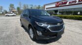 Close-up view of a black SUV in the dealership lot with an E-Z Loan Auto building in the background on a sunny day.