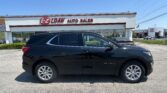 Black Equinox SUV parked in front of an auto dealership with the 'E-Z LOAN AUTO SALES' sign and a clear blue sky.