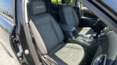 Interior of a dark SUV showing front seats with embroidered EQUINOX logos on the headrests, center console, and door panel visible.