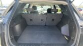 Open SUV rear hatch showing the cargo area with rear seats upright and headrests, parking lot in background.