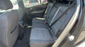 Rear car seating: back bench with three seat belts and headrests, visible door panel and sunlight outside