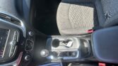 Interior of a car showing the front seats, center console with a gear shifter, cup holders, and dashboard controls on the left side of the cabin.