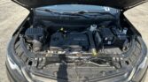 Open hood reveals engine bay with EcoTec engine cover and various components visible under the trunk lid of a Chevrolet car, front view centered on the engine.