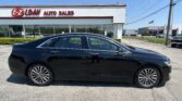 Black sedan parked in front of E-Z Loan Auto Sales on a sunny day.