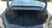 Open car trunk with empty storage space and rear seats visible through the rear window.