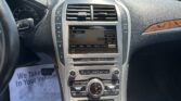 Center console of a car showing a touchscreen infotainment system, air vents, and climate controls in a vehicle cabin.