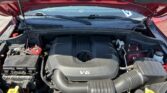 Car hood open showing V6 engine and surrounding components in the engine bay.