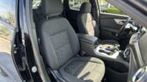 Interior of a dark SUV with the front seats visible and center console between them, steering wheel on the right side of the image.