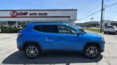 Blue SUV parked in front of EZ LOAN Auto Sales on a sunny day, storefront sign visible.