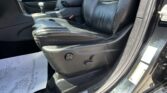 Black leather car interior with front driver’s seat, center console and gear shifter, and door panel visible.