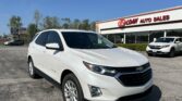 White Chevrolet Equinox parked in front of EZ LOAN Auto Sales on a sunny day.