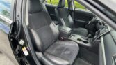 Open car door showing black cloth seats with red stitching in the front cabin, center console and steering wheel visible.