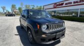 Black Jeep SUV parked in front of a red-and-white E-Z LOAN Auto Sales storefront on a sunny day.