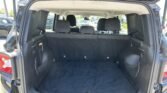 Open tailgate reveals a large SUV cargo space with rear seats up and black carpeting.