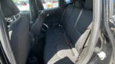 Back seat area of a dark-cloth SUV with three headrests and three-point seat belts, view from the open rear doorportions visible through windows.