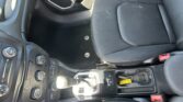 Interior of a car showing the center console with gear shifter, climate controls, and cupholder area near the front seats.
