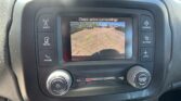 Car dashboard touchscreen showing the rear-view camera with green and yellow parking guide lines while backing up