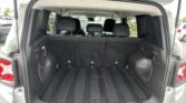 Open SUV cargo area with third-row seats upright and spacious dark carpeted trunk space